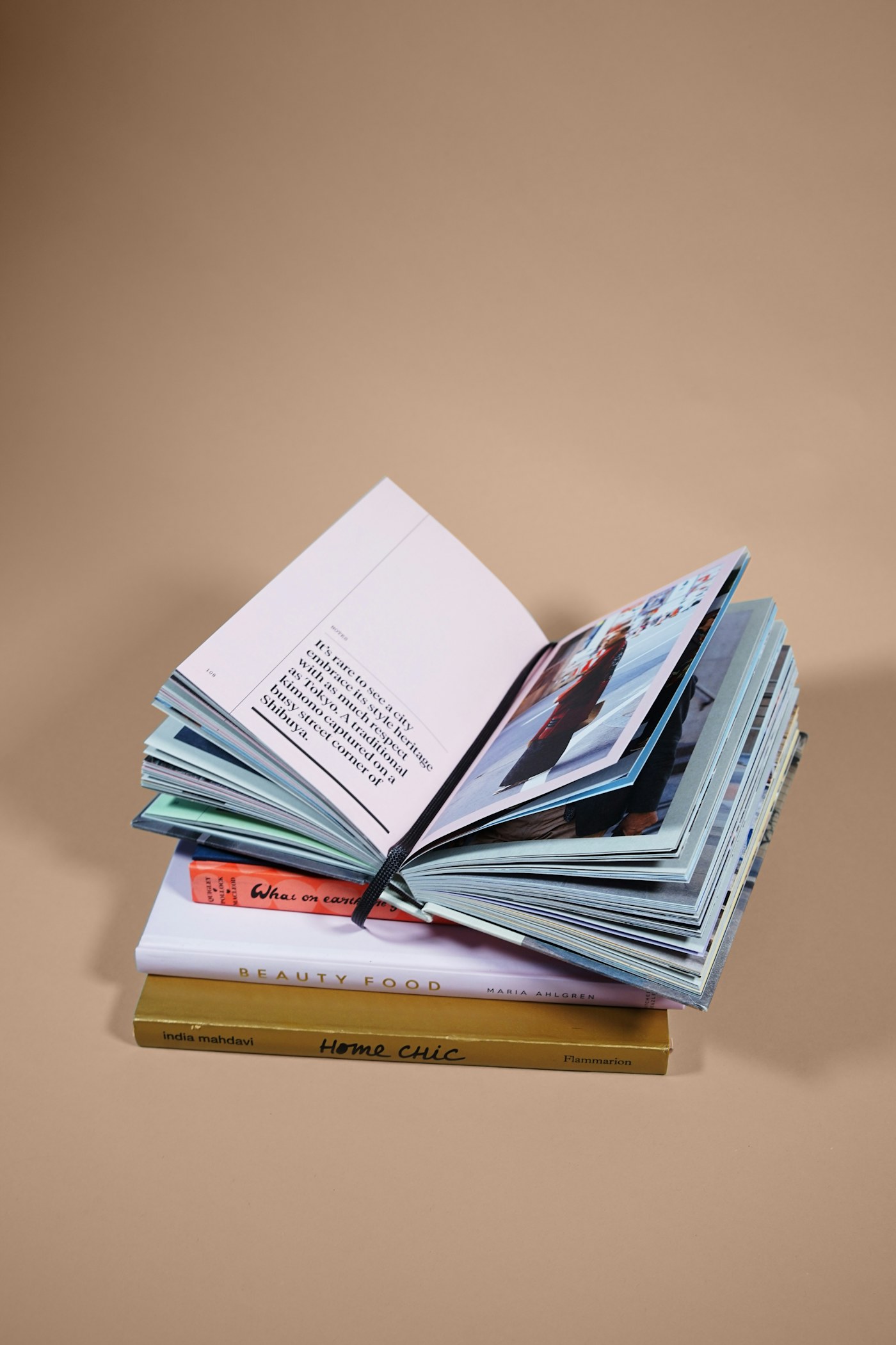 Ein aufgeschlagenes illustriertes Buch liegt auf einem Stapel verschiedener Bücher